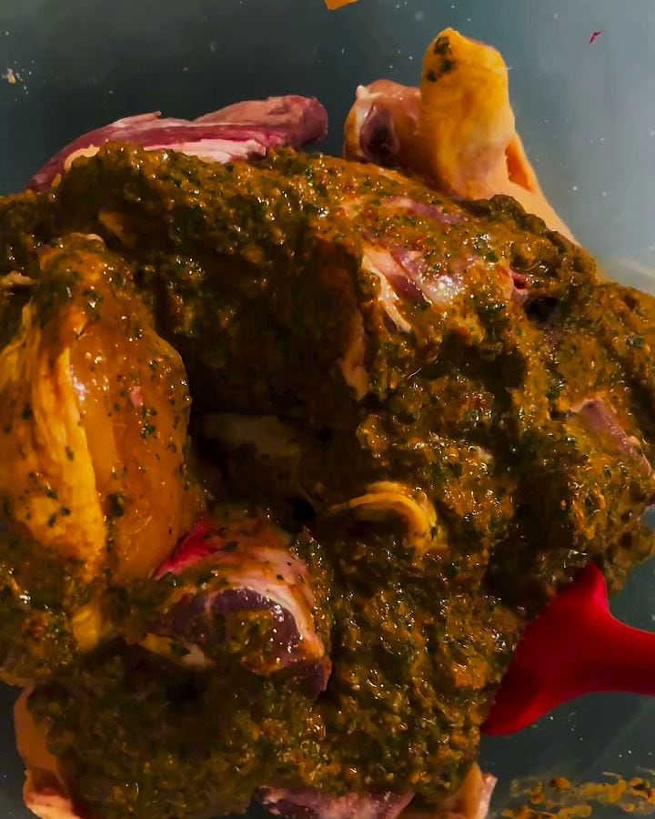 Grosse pièce de viande entièrement enrobée de marinade verte, dans son plat.