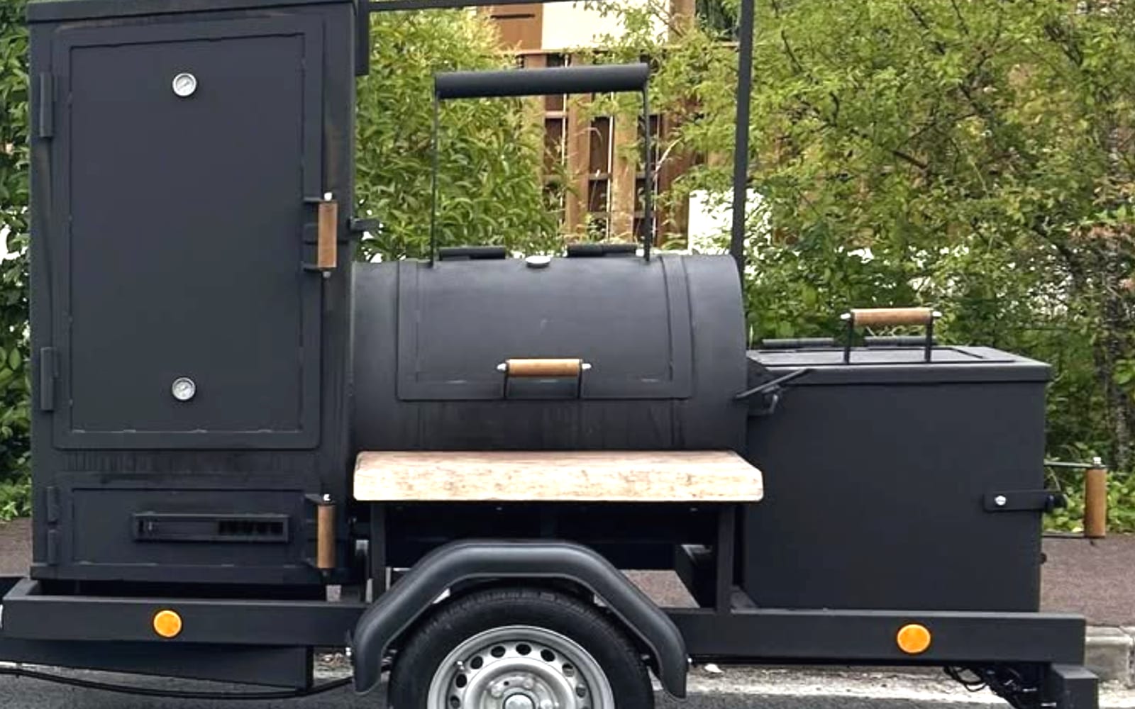 Le smoker Hunter X Smoker sur sa remorque : chambre de cuisson verticale, cuve, foyer et plan de travail.